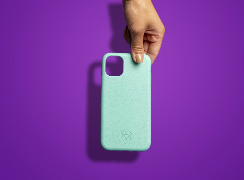 Hand holding a reboxed eco phone case from above against a purple background